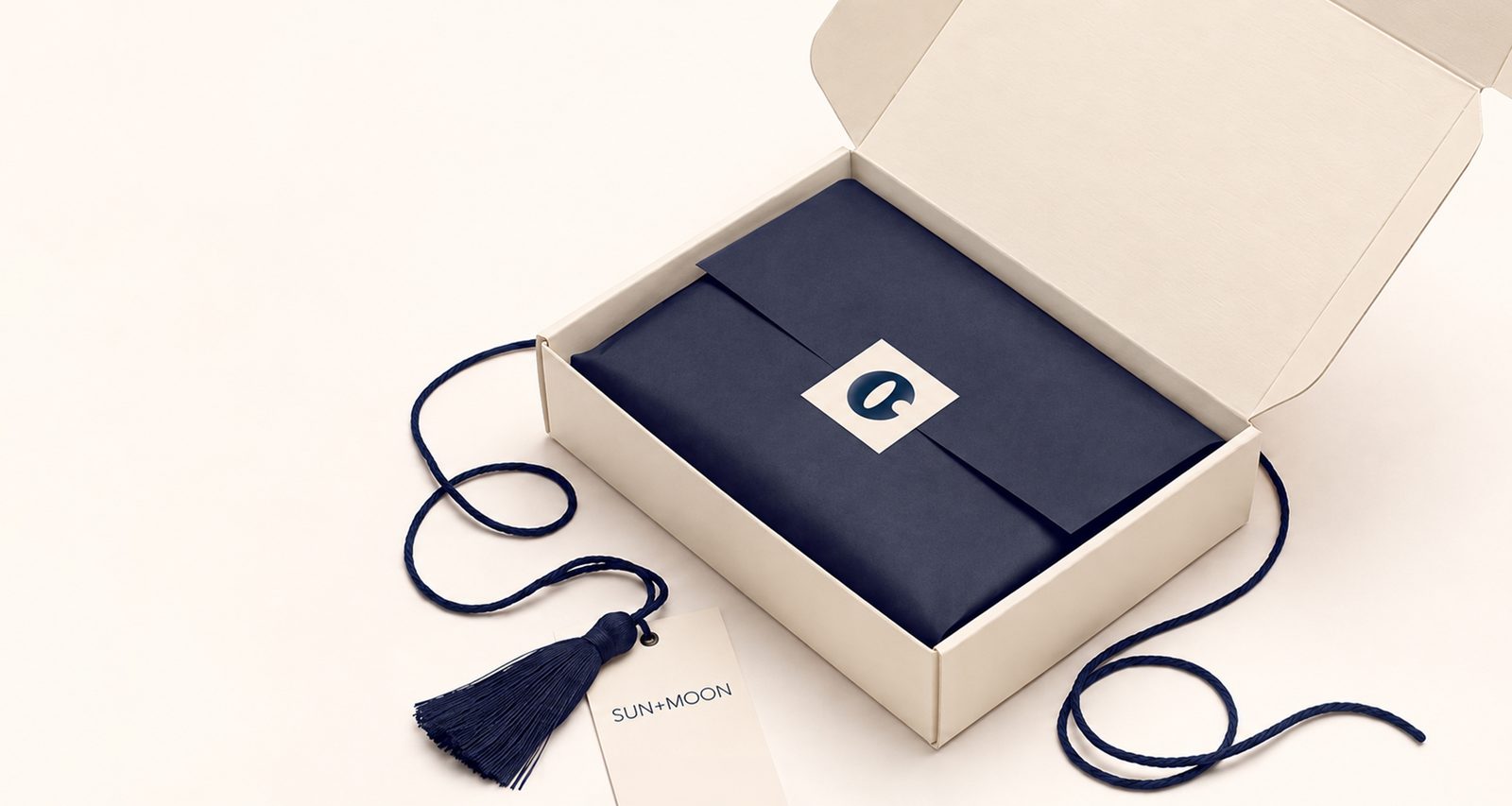 SUN+MOON gift box with navy wrapping and a tassel tag